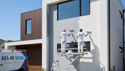 Professional house painters working on residential exterior in Grand Rapids MI